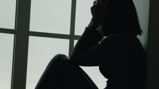 sfrustrowana czarna dziewczyna w pobliżu okna - Materiał filmowy, wideo