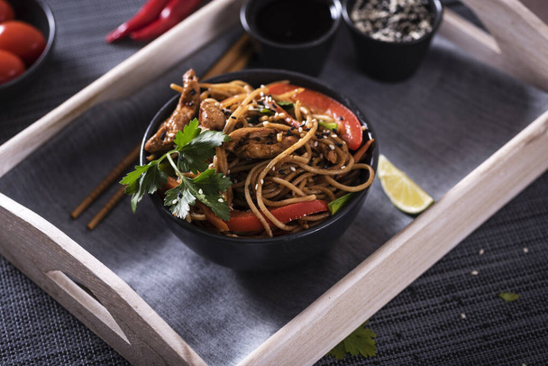 Japanese dish buckwheat noodles soba with chicken and vegetables carrots, bell peppers, mushrooms, green onions - Photo, image