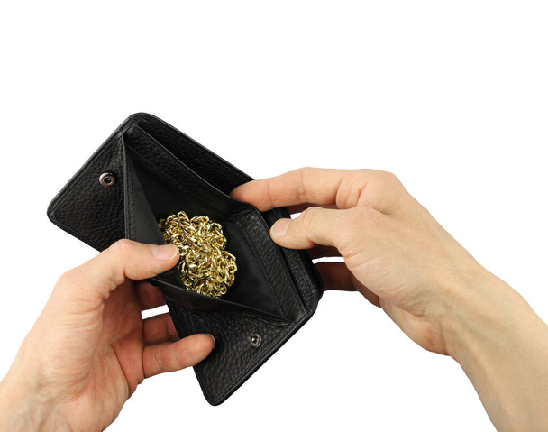 detailní lidské ruce drží otevřenou černou koženou peněženku se zlatožlutým řetízkem na šperky, koncept investice do zlata nebo zastavárny nebo krádeže zločinu, neočekávané štěstí nebo poklad v kabelce, izolované - Fotografie, Obrázek