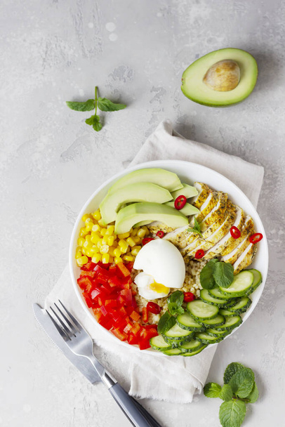 Buddha bowl with soft boiled egg, avocado, grilled chicken, cucumber, bell pepper, corn and bulgur. Concept for clean and balanced healthy food.  - Zdjęcie, obraz
