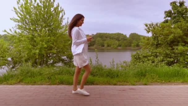 profilo femminile utilizzando mobile passeggiate alcoliche lungo il lago
 - Filmati, video