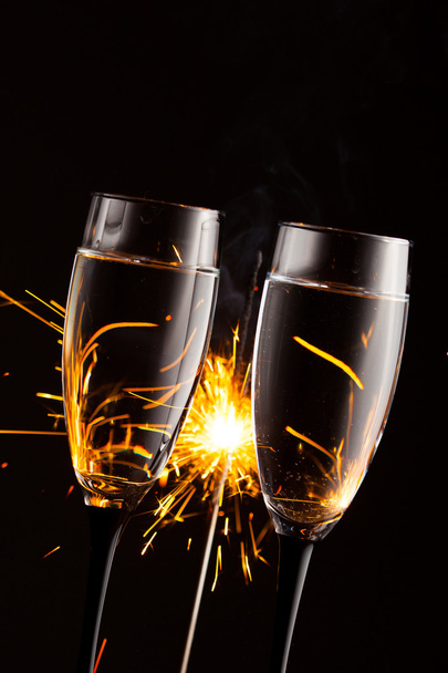 champagne glasses against christmas sparkler background - Photo, Image