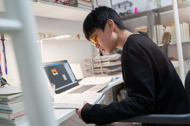 Азиатский ребенок учится из дома на ноутбуке носить компьютерные очки во время covid-19
 - Фото, изображение