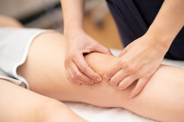 Fizjoterapeutka wykonująca zabieg na kolanach kobiet. - Zdjęcie, obraz