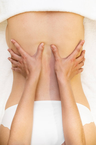 Junge Frau erhält Rückenmassage in einem Wellness-Center - Foto, Bild