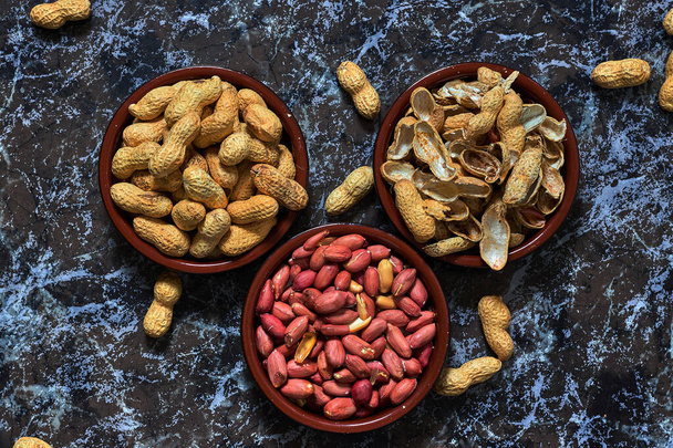 Kaksi kulhoa maapähkinöitä ja yksi kuorineen
 - Valokuva, kuva