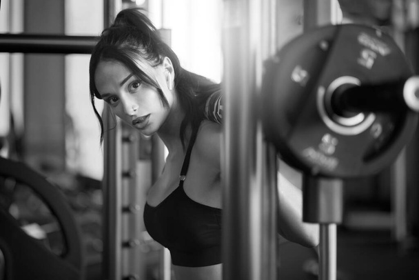 Sportswoman training in smith machine, monochrome. - Фото, зображення
