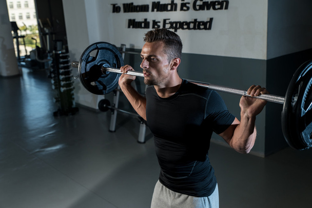 Young Man In Black T-Shirt Doing Barbell Squat - Photo, image