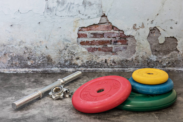 halteres profissionais e placas de peso multi-coloridas em um fundo vintage. Equipamento desportivo. Estilo de vida saudável
 - Foto, Imagem