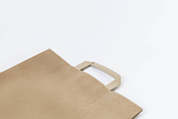 Sacchetto di carta Kraft marrone su sfondo bianco, sacchetto di carta vuoto per prodotti da imballaggio. Protezione dell'ambiente. Ecoconcetto
 - Foto, immagini