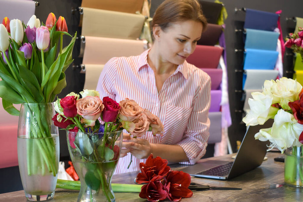 The florist accepts the flowers. Flower delivery. Florist girl at the Desk in the room - Fotó, kép