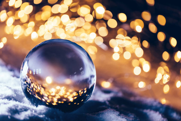 Boule de verre de Noël sur neige. Des lumières brillent. Carte de vœux élégante
 - Photo, image