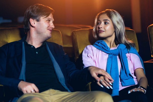 Caucasian lover enjoying to watch movie and eating popcorn together in the cinema - Foto, afbeelding