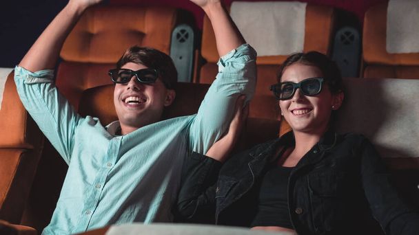 Άνδρας και γυναίκα στον κινηματογράφο βλέποντας μια ταινία με τρισδιάστατα γυαλιά. με ενδιαφέρον κοιτάζοντας την οθόνη, συναρπαστικό και τρώει ποπ κορν - Φωτογραφία, εικόνα