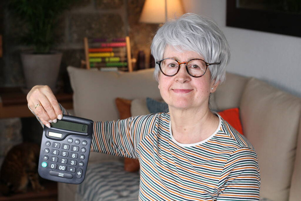 Zaniepokojony starszy kobieta gospodarstwa kalkulator - Zdjęcie, obraz