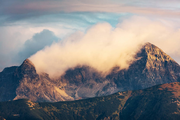 Bergtoppen in de wolken bij zonsondergang. Tatra gebergte, Polen. Uniek perspectief - Foto, afbeelding