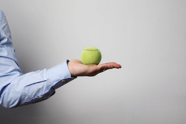 Hand holding tennis ball isolated on white background. Isolated. - Photo, Image