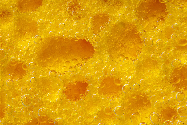 vaatwasspons. Oppervlakte gele spons voor afwassen. close-up onderwater - Foto, afbeelding
