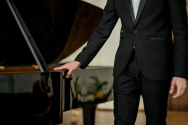 portrait of man standing next to piano - Photo, Image