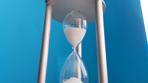 Elegant hourglass on a blue background. Concept-business time money, education, time is running out, time management, time resource, fulltime, deadline. - Footage, Video