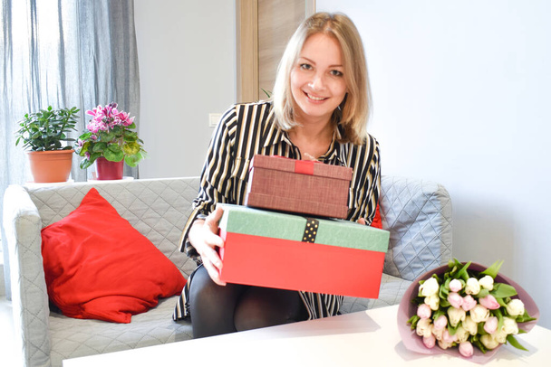 Beautiful girl opens a gift box at home. To give a gift for the holiday. - Foto, Bild