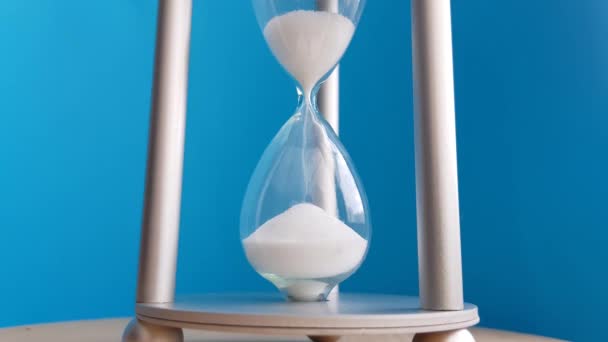 Elegant hourglass on a blue background. Concept-business time money, education, time is running out, time management, time resource, fulltime, deadline. - Footage, Video