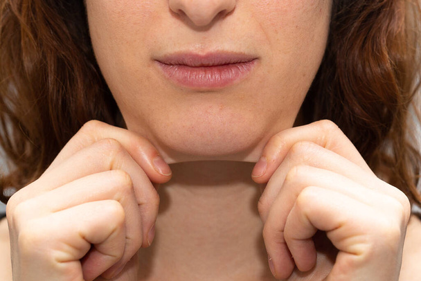 Girl highlighting double chin by pulling skin under chin - Fotó, kép