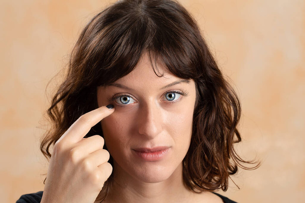 Girl with a finger near the eye to arrange contact lenses. Conce - Fotoğraf, Görsel