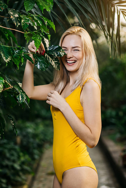 Woman in swimsuit on tropical plants background - Photo, Image