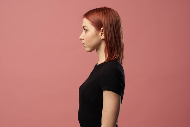 Young woman in black t-shirt isolated on pink background in studio - Φωτογραφία, εικόνα