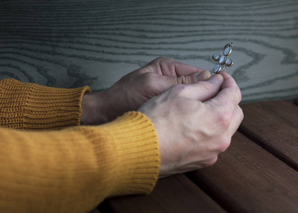 Молитва с четками на деревянном фоне, страх пандемии
 - Фото, изображение