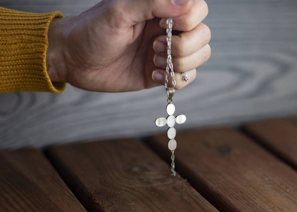 Pregare con un rosario su sfondo ligneo, paura della pandemia
 - Foto, immagini