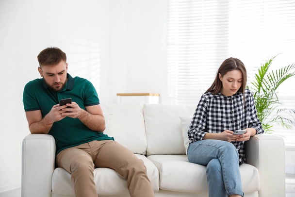 Couple addicted to smartphones ignoring each other at home. Relationship problems - Foto, Imagem