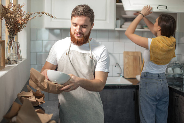 moving day, couple standing together in kitchen, unpacking carton package - Valokuva, kuva