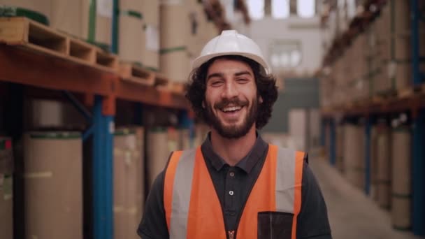 Retrato de um trabalhador de armazém caucasiano em pé em grande centro de distribuição de armazém sorrindo e olhando para a câmera
 - Filmagem, Vídeo