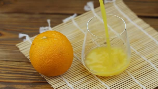 Pyszny świeżo wyciskany sok mandarynkowy w przezroczystym szkle - Materiał filmowy, wideo