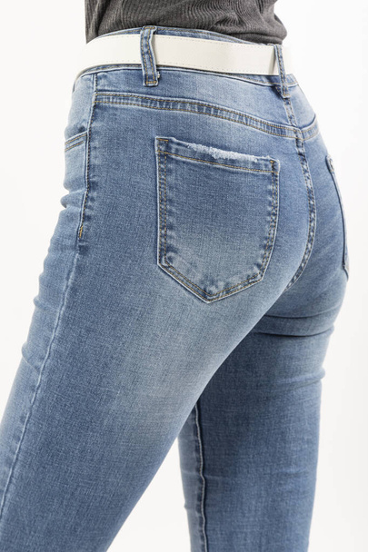 girl in jeans shows jeans back pockets on a white background close-up, blue jeans - Photo, Image
