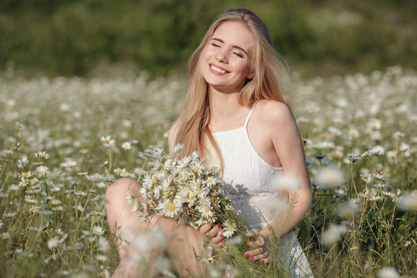 piękna młoda kobieta na polu rumianku w malowniczej dolinie. szczęśliwa młoda dama i wiosenna zielona natura, koncepcja harmonii. ideę samoopieki, zdrowego stylu życia i pozytywnego nastawienia - Zdjęcie, obraz
