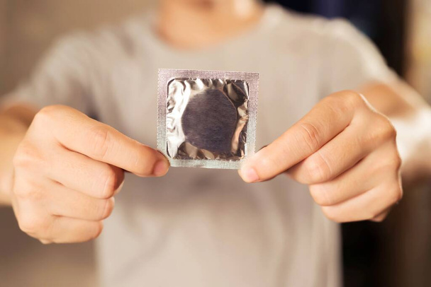 Men carry condoms before having sex every time to prevent AIDS. - Fotoğraf, Görsel