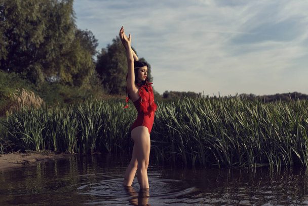 Young girl in red by the river - Foto, imagen