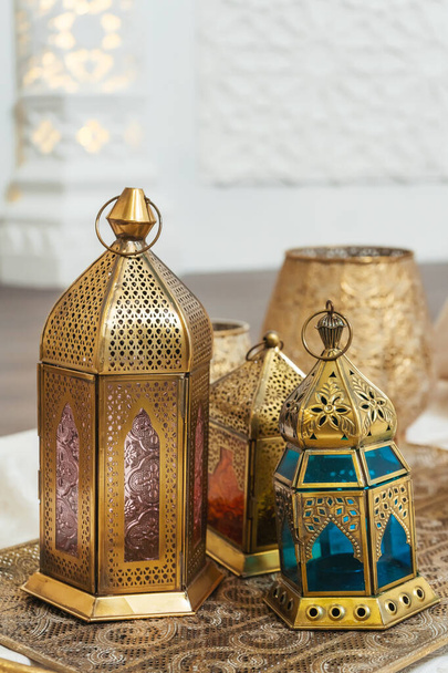 Faroles de bronce orientales en una bandeja tallada en oro detalles interiores. Faroles metálicos candelabros de estilo árabe. Decoración en diseño de estilo oriental
 - Foto, Imagen