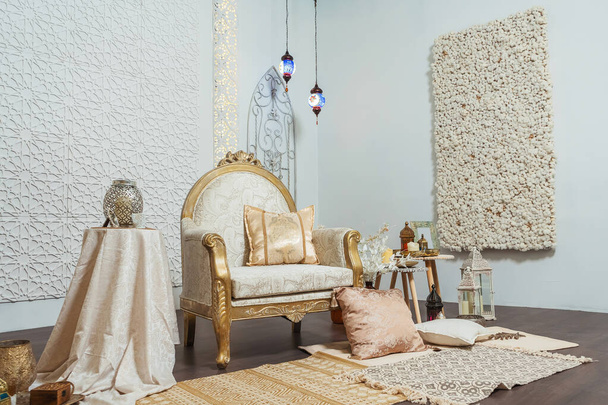 Cadeira interior branca e dourada e mesas em estilo oriental. Marroquino Médio Oriente Decoração em estilo árabe oriental design. Quarto branco em estilo oriental
 - Foto, Imagem