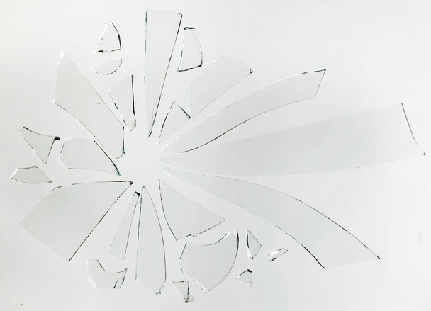 Pequenos pedaços de vidro quebrado em uma superfície branca
 - Foto, Imagem
