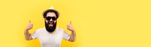 homem alegre com humor fresco verão sobre o fundo amarelo na moda, conceito de umas férias legais, mock-up panorâmico
 - Foto, Imagem