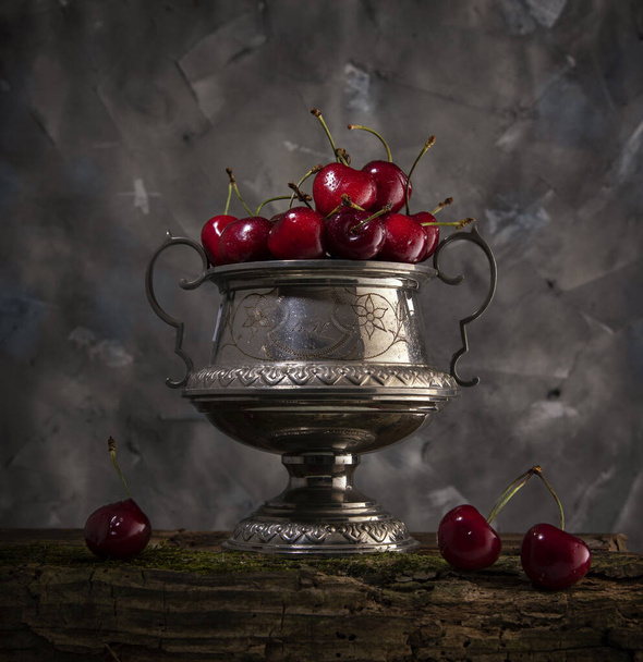 Süßkirsche in einer alten Vase auf grauem Hintergrund - Foto, Bild