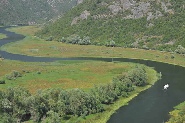 Crnojevia folyó, a Skadar-tó része Montenegróban. Turista körutazások hajóval a gyönyörű kanyargós a folyó folyik a hegyek között. - Fotó, kép