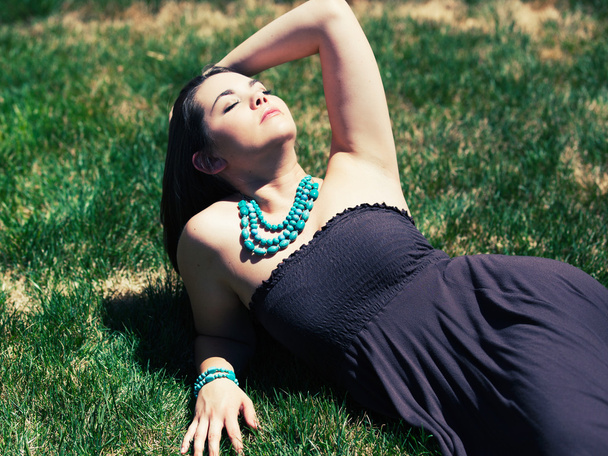 mooie brunette vrouw leggen in gras - Foto, afbeelding