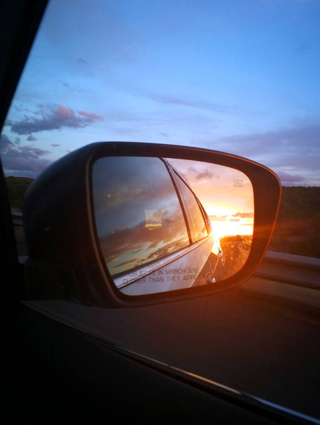 Belo pôr do sol no espelho de um carro
 - Foto, Imagem