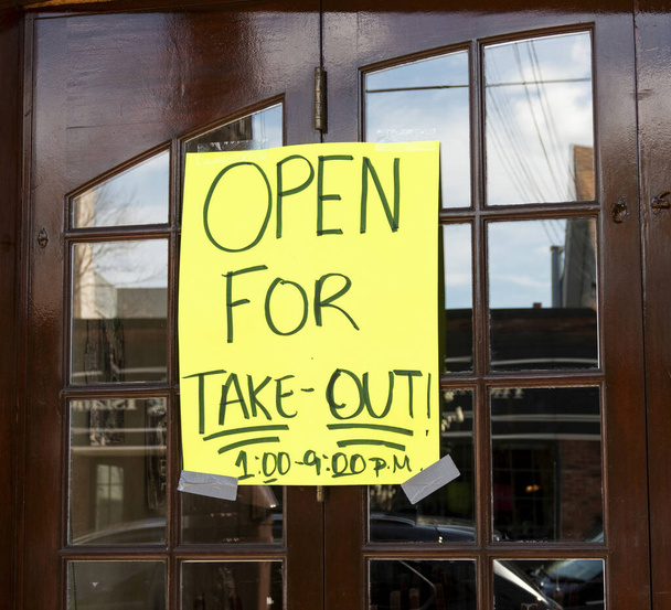Open for take out only sign posted on the windows of a restaurant in Babylon Village New York USA because of the coronavirus COVID-19 pandemic. - Photo, Image