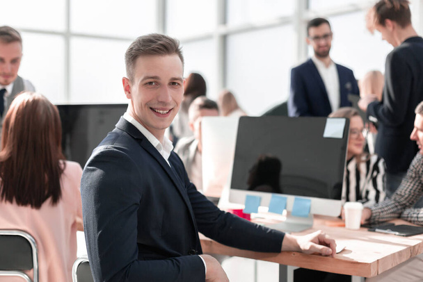 young businessman sitting at his Desk and looking at the camera - Foto, Bild